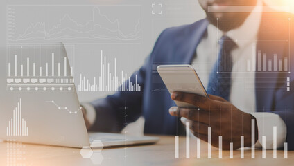 Aufkleber - African American businessman using cellphone and laptop at workplace, collage with company analytics on imaginary screen