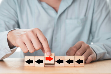 Sticker - Disruption  and different thinking concept , businessman holding red arrow among black arrow which print screen on wooden cube block and it opposite direction.