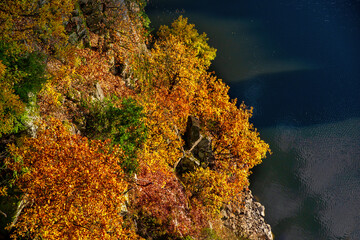 Rock hill with autumn color leaf forest and lake.