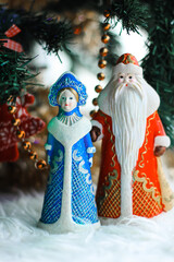 Wall Mural - Christmas decorations (Russian Santa Claus and Snow Maiden) standing near with Christmas tree. New Year, holiday background.