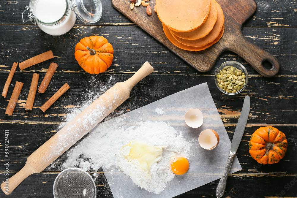 Tasty pumpkin pancakes with ingredients on table