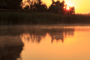 The shore with steaming water at dawn 