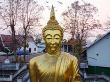 Nan / Thailand -February 2020 : Wat Phra That Khao Noi Temple In Northern Thailand With A Large Golden Standing Buddha Statue Over Looking The City From The Mountain Top In Sunset