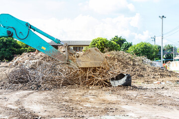 Closeup front loader truck clearing old steel bar at construction site, construction industry 