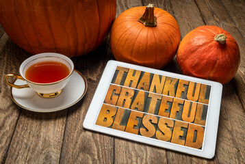 Wall Mural - thankful, grateful and blessed inspirational words on a digital tablet with pumpkins and hot tea against rustic wood, Thanksgiving theme