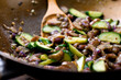 © Andrew Scrivani - Close up of onion and zucchini in frying pan