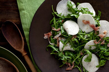 Close Up Of Turnip Salad With Arugula And Prosciutto Served On Plate