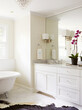 © Alexis Courtney/Stocksy - Master bathroom with orchid