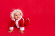 © Any Grant - child on a red background in a Santa suit, the concept of new year and Christmas, place for text