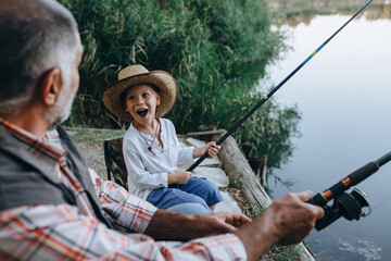 Wall Mural - boy fishing with his grandfather by the lake