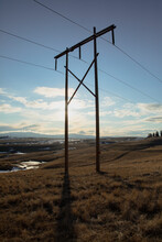 Powerlines Crossing A Field In Grasslands