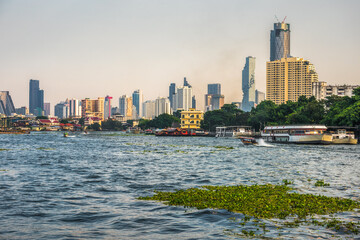 Wall Mural - City Skyline as Seen from the Tourist Boat on Chao Phraya River in Bangkok, Thailand