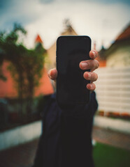 Sticker - Closeup of a hand holding a black phone