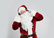© New Africa - Santa Claus with headphones listening to Christmas music on light grey background