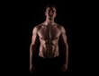© Anetta - Muscular male torso of fit bodybuilder on black background