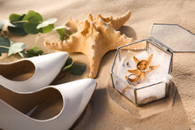 Composition With Gold Wedding Rings On Sandy Beach