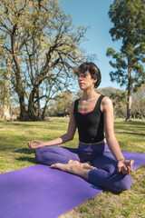 Canvas Print - Vertical shot of a young Caucasian female doing yoga practice in the park