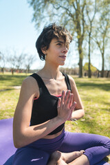 Canvas Print - Vertical shot of a young Caucasian female doing yoga practice in the park