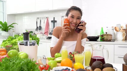 Wall Mural - Healthy young woman in a kitchen with fruits and vegetables and juice