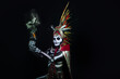 © ClicksdeMexico - hombre latino , catrin de dios azteca, calavera prehispanica, con saumerio e incienso y fuego, portado penacho de plumas amarillas y rojas en fondo negro, dia de muertos, 1 de noviembre, calaca,