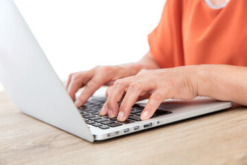 Wall Mural - Closeup old man's hands typing enter on laptop keyboard