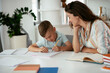 © JustLife - Mother helping her son with homework at home. Little boy learning at home..
