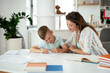 © JustLife - Mother helping her son with homework at home. Little boy learning at home..