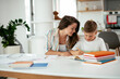 © JustLife - Mother helping her son with homework at home. Little boy learning at home..