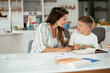 © JustLife - Mother helping her son with homework at home. Little boy learning at home..