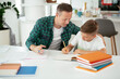 © JustLife - Father helping his son with homework at home. Little boy learning at home.