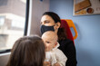 © Christian - Woman looking through the window of a bus and sitting alongside her daughters