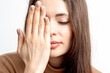 © okskukuruza - Portrait of beautiful young woman with closed eyes covering one eye by her hand on white background