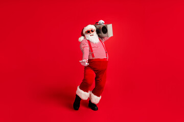 Poster - Full length body size view of his he handsome bearded fat overweight cheerful cheery Santa having fun listening pop carrying cassette player isolated bright vivid shine vibrant red color background