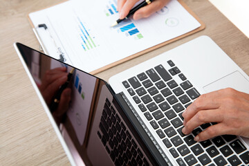 Wall Mural - Female workers check financial data while operating laptops