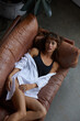 © Flamingo Images - Young woman relaxing on her leather sofa
