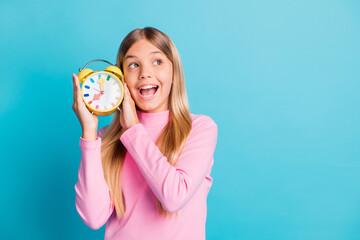 Sticker - Photo portrait of curious girl showing colorful clock listening looking at blank space isolated on bright turquoise color background