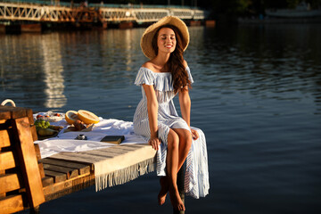 Wall Mural - Young woman spending time on pier at picnic