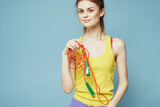 Fototapeta  - Woman with skipping rope sport exercise yellow tank top blue background