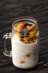 Wall Mural - delicious granola with yogurt, nuts, peach, blueberry in glass jar