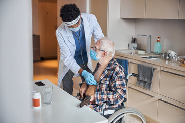 Wall Mural - Experienced young doctor performing the cardiac auscultation