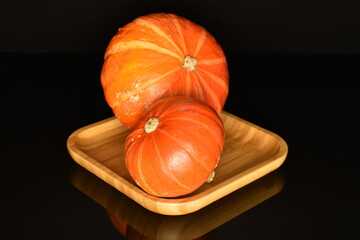 Ripe organic pumpkin, close-up, on a black background.