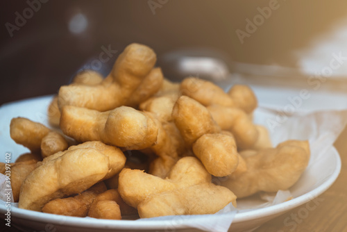 Fotografía Patongko or deep-fried dough sticks, traditional morning snack or breakfast of Thai and Chinese, close up Patongko or deep-fried dough sticks in white plate