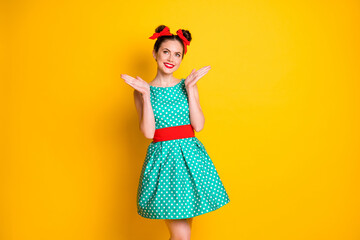 Poster - Portrait of lovely pretty cheerful girl wearing teal short dotted dress clapping palms isolated over bright yellow color background