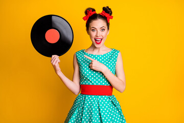 Canvas Print - Portrait of attractive cheerful amazed girl holding in hands showing vinyl disc isolated on vibrant yellow color background