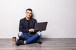 © dianagrytsku - Young man working on laptop sitting on floor reading news, surfing net or freelancing isolated on white background