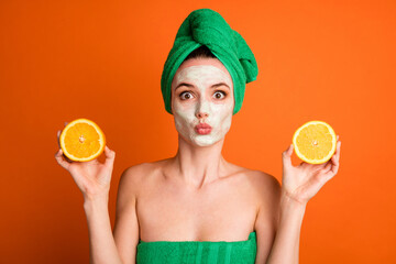 Photo of surprised funny lady wear green towel head applying fruit mask face arms made lips pouted isolated orange color background