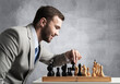 © adam121 - Concentrated businessman playing chess game