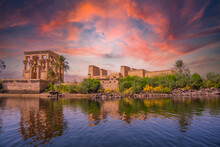 Incredible Orange Sunrise At The Temple Of Philae, A Greco-Roman Construction Seen From The Nile River, A Temple Dedicated To Isis, Goddess Of Love. Aswan. Egyptian