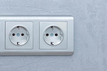 Electrical sockets on the wall made of decorative plaster. The concept of decor in household premises. Copyspace