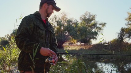 Wall Mural - Fisherman on the river. Amateur angler fishing on the river from its coast